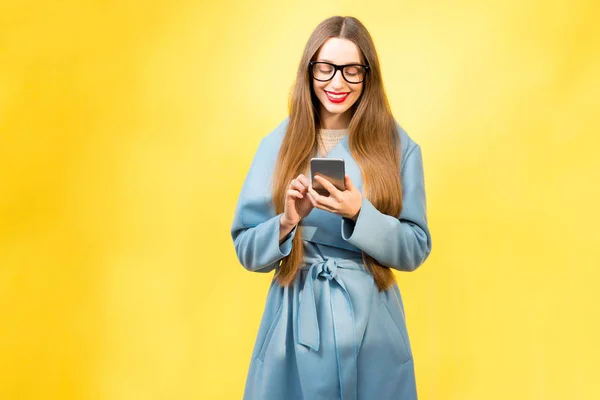 Žena v plášti pomocí chytrého telefonu — Stock fotografie