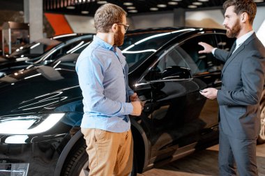 Galeride elektrikli arabaları olan bir satıcıyla müşteri.