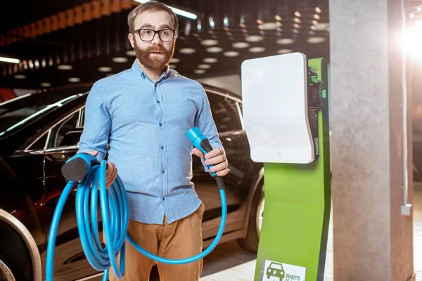 男人在汽车经销店选购充电器 — 图库照片