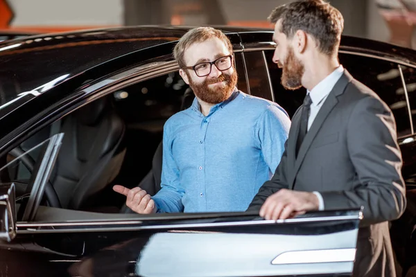 Client with a salesman at the showroom with electric cars — Stock Photo, Image