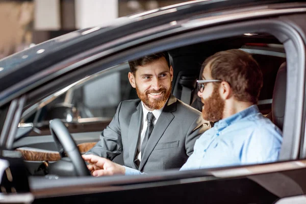 销售经理与客户一起检查汽车内部 — 图库照片