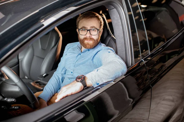 Retrato de un hombre en el coche eléctrico nuevo — Foto de Stock