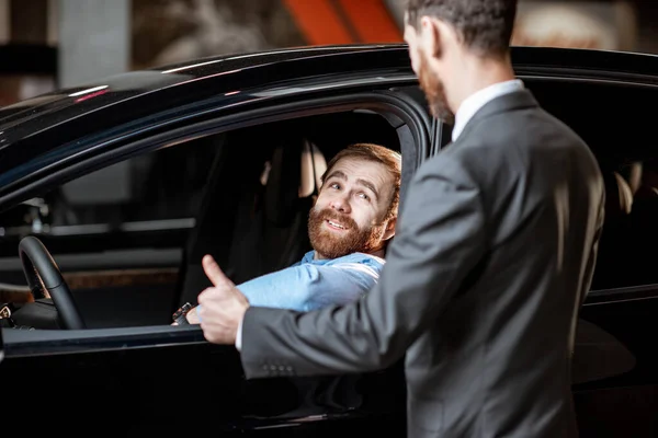 销售经理与客户一起检查汽车内部 — 图库照片