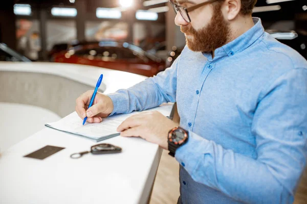 Man buying a new car at the dealership — Stock Photo, Image