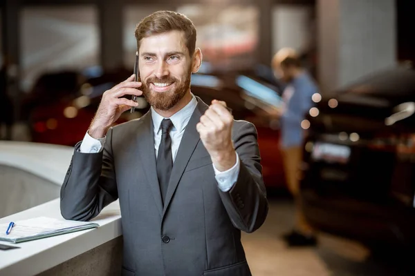 Homme d'affaires avec clé de voiture dans la salle d'exposition — Photo