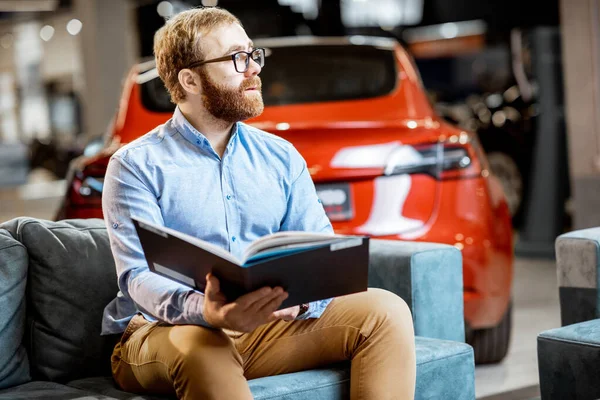 stock image Man with catalog in the car dealership