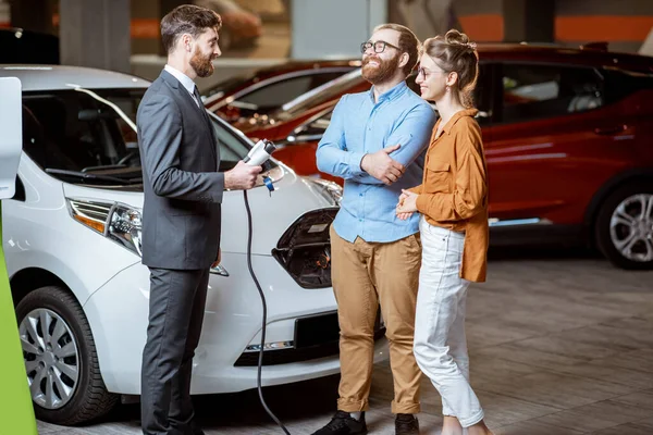 Sales manager selling electric car to a young couple