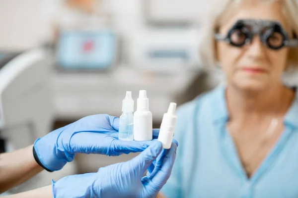 Holding eye medicine with senior patient — ストック写真