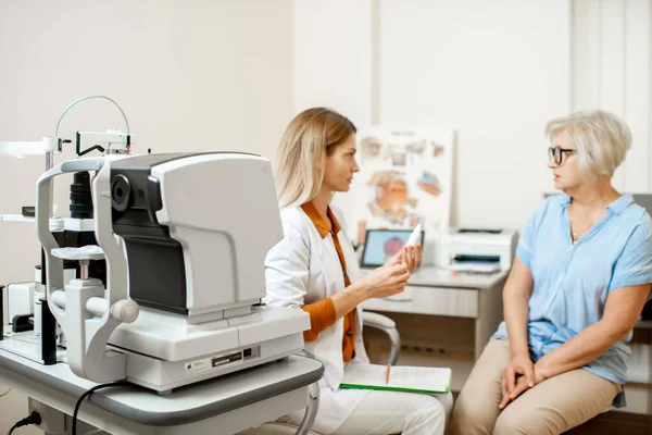 Paciente sênior com oftalmologista no consultório — Fotografia de Stock