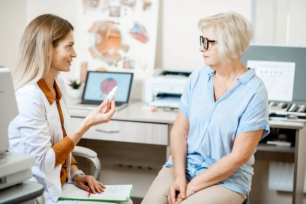 Senior patiënt met oogarts op kantoor — Stockfoto