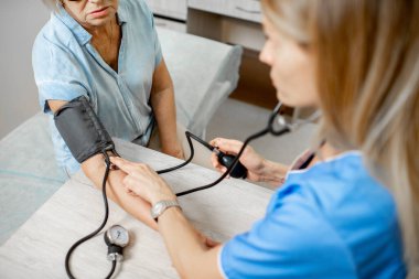 Üst düzey bir hastanın tansiyonunu ölçen hemşire.