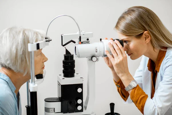 Augenarzt untersucht Augen mit dem Mikroskop — Stockfoto