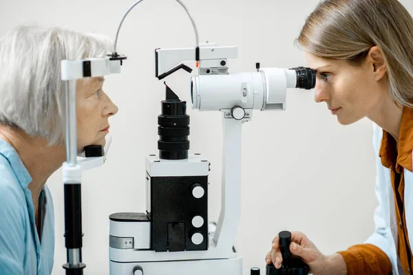 Ophtalmologiste examinant les yeux au microscope — Photo