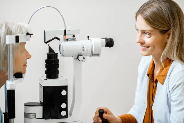 Ophtalmologiste examinant les yeux au microscope — Photo