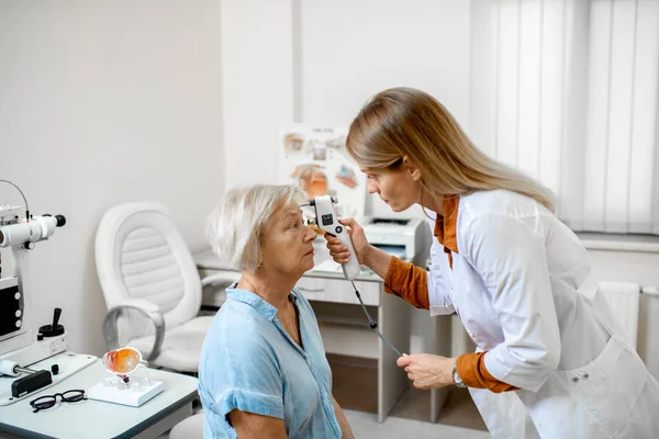 Oftalmologista medindo pressão ocular para uma mulher idosa — Fotografia de Stock