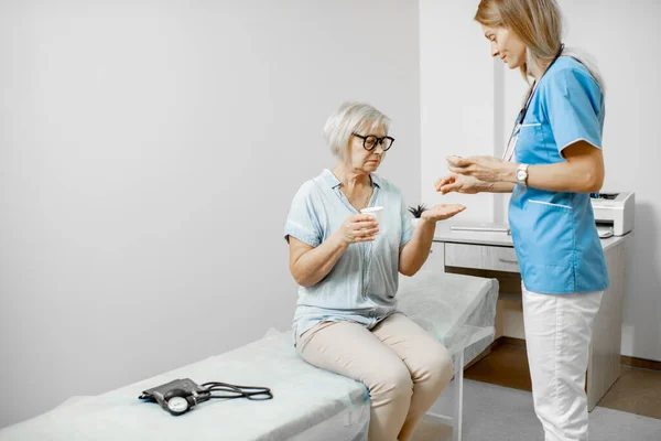 A nővér gyógyszert ad egy idős betegnek. — Stock Fotó