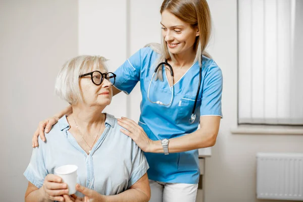 Nurse taking care of senior woman — Stock Photo, Image