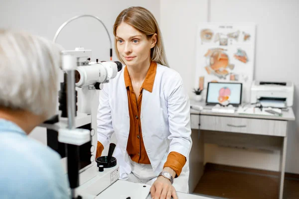 Ophthalmologist examining eyes with a microscope — Stock Photo, Image