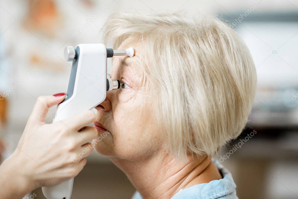 Measuring the eye pressure to a senior woman