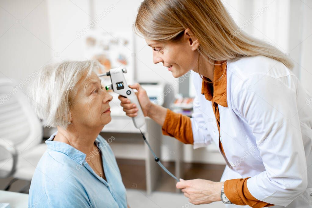 Ophthalmologist measuring eye pressure to a senior woman