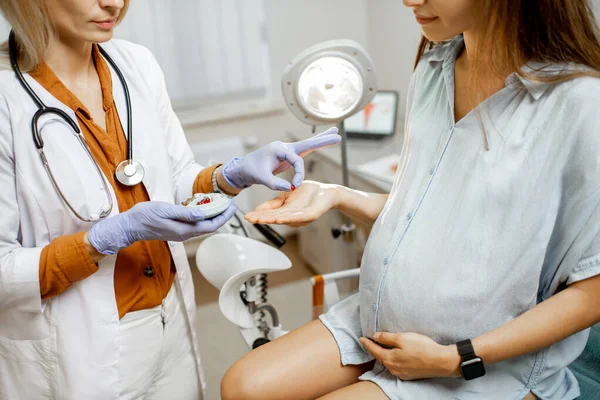Гинеколог дает лекарство для молодой беременной женщины — стоковое фото