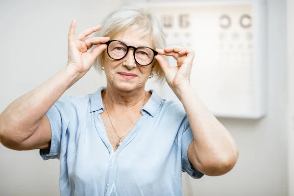 Portrét starší ženy s brýlemi v lékařské ordinaci — Stock fotografie