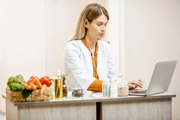 Nutriční lékař s produkty v lékařské ordinaci — Stock fotografie