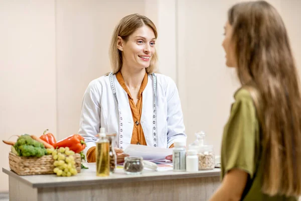 Táplálkozási szakértő női ügyféllel az irodában — Stock Fotó