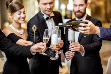 İyi giyimli insanlar içeride yeni yılı kutluyorlar.