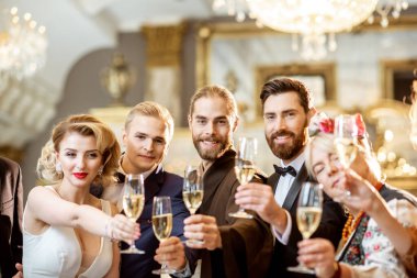 Kapalı alanda kutlama yapan zarif insanlar.