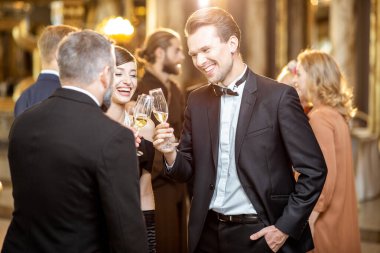 Kapalı alanda kutlama yapan zarif insanlar.