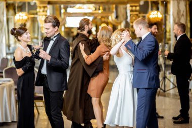 Bir grup zarif insan içeride dans ediyor.