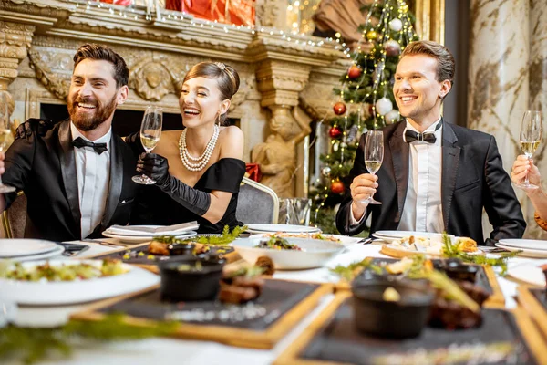 Elegantly dressed people having a festive dinner indoors — ストック写真