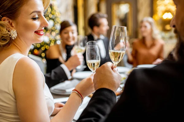 Элегантно одетые люди устраивают праздничный ужин в помещении — стоковое фото
