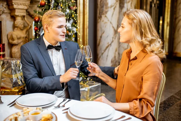 Elegantemente vestida pareja teniendo una cena festiva en Nochevieja —  Fotos de Stock