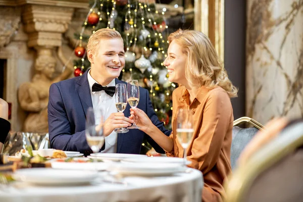 Elegant klädda par som har en festlig middag på nyårsafton — Stockfoto