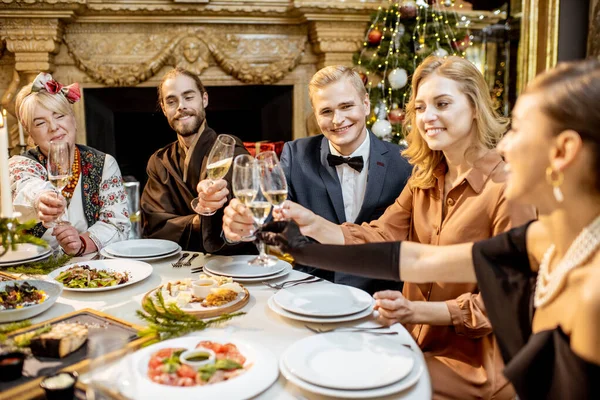 Elegant klädda människor som har en festlig middag inomhus — Stockfoto