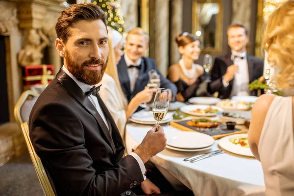 Yılbaşı arifesinde arkadaşlarıyla yemek yiyen bir adam. — Stok fotoğraf