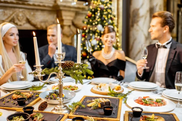 Elegantly dressed people having a festive dinner indoors — ストック写真