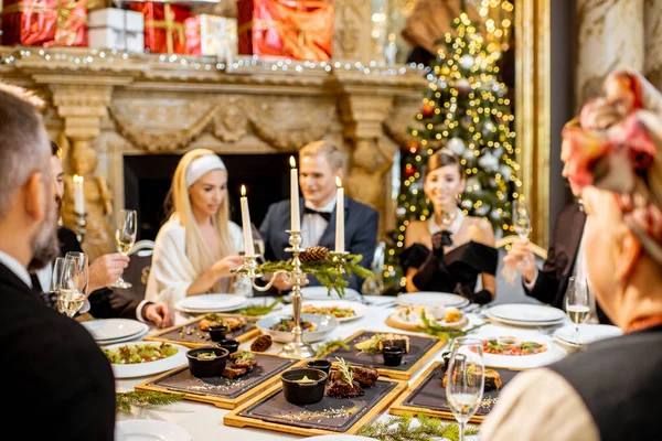 Elegantemente vestita persone che hanno una cena festiva in casa — Foto Stock