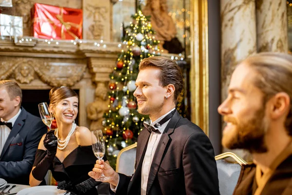 Elegantly dressed people having a festive dinner indoors — ストック写真