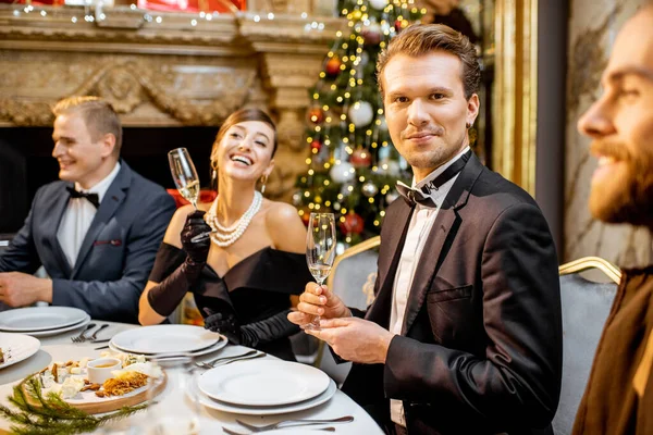 Hombre con amigos durante una cena festiva en Nochevieja — Foto de Stock