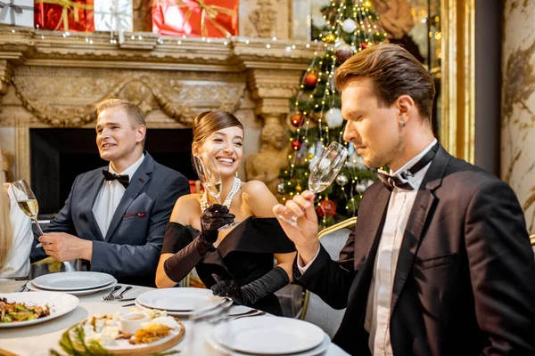 Elegantemente vestita persone che hanno una cena festiva in casa — Foto Stock