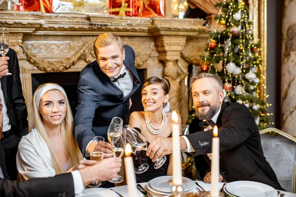 Elegantly dressed people celebrating New Year holiday indoors — ストック写真