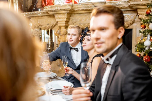 Elegantně oblečení lidé mají slavnostní večeři uvnitř — Stock fotografie