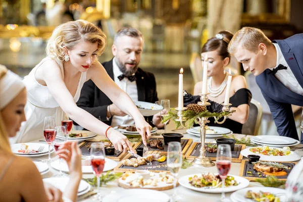 Pessoas elegantemente vestidas tendo um jantar festivo dentro de casa — Fotografia de Stock