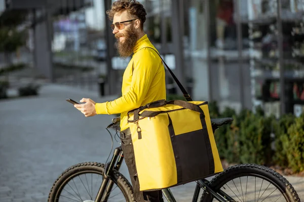 Homem entregando comida com saco térmico em uma bicicleta — Fotografia de Stock