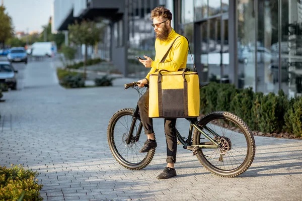 Homem entregando comida com saco térmico em uma bicicleta — Fotografia de Stock