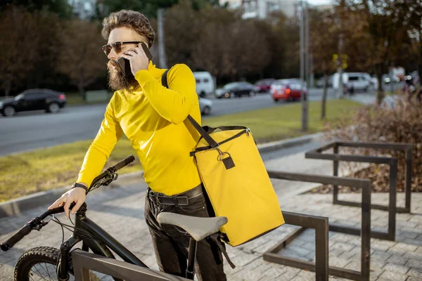 Homem entregando comida com saco térmico em uma bicicleta — Fotografia de Stock