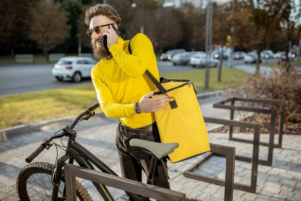 Homem entregando comida com saco térmico em uma bicicleta — Fotografia de Stock